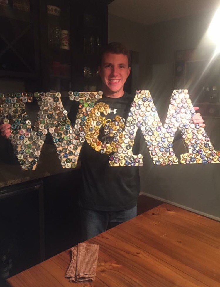 Oakton High School senior Ben Wagner with the sign of his selected college being William and Mary. 