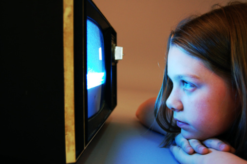 Child laying on stomach watching a blank tv screen